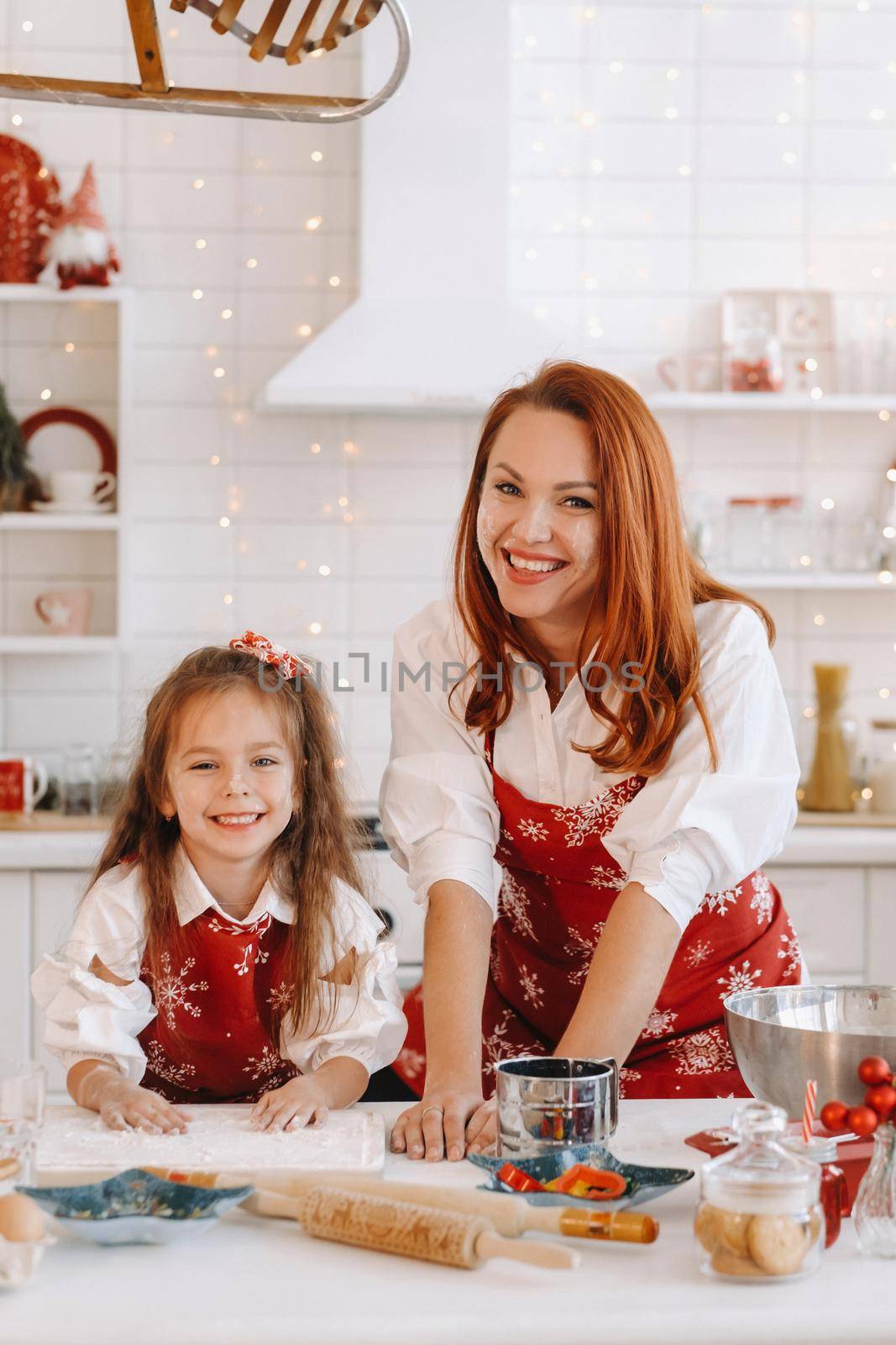 Mom and daughter in the New Year's kitchen together prepare dough for Christmas cookies.