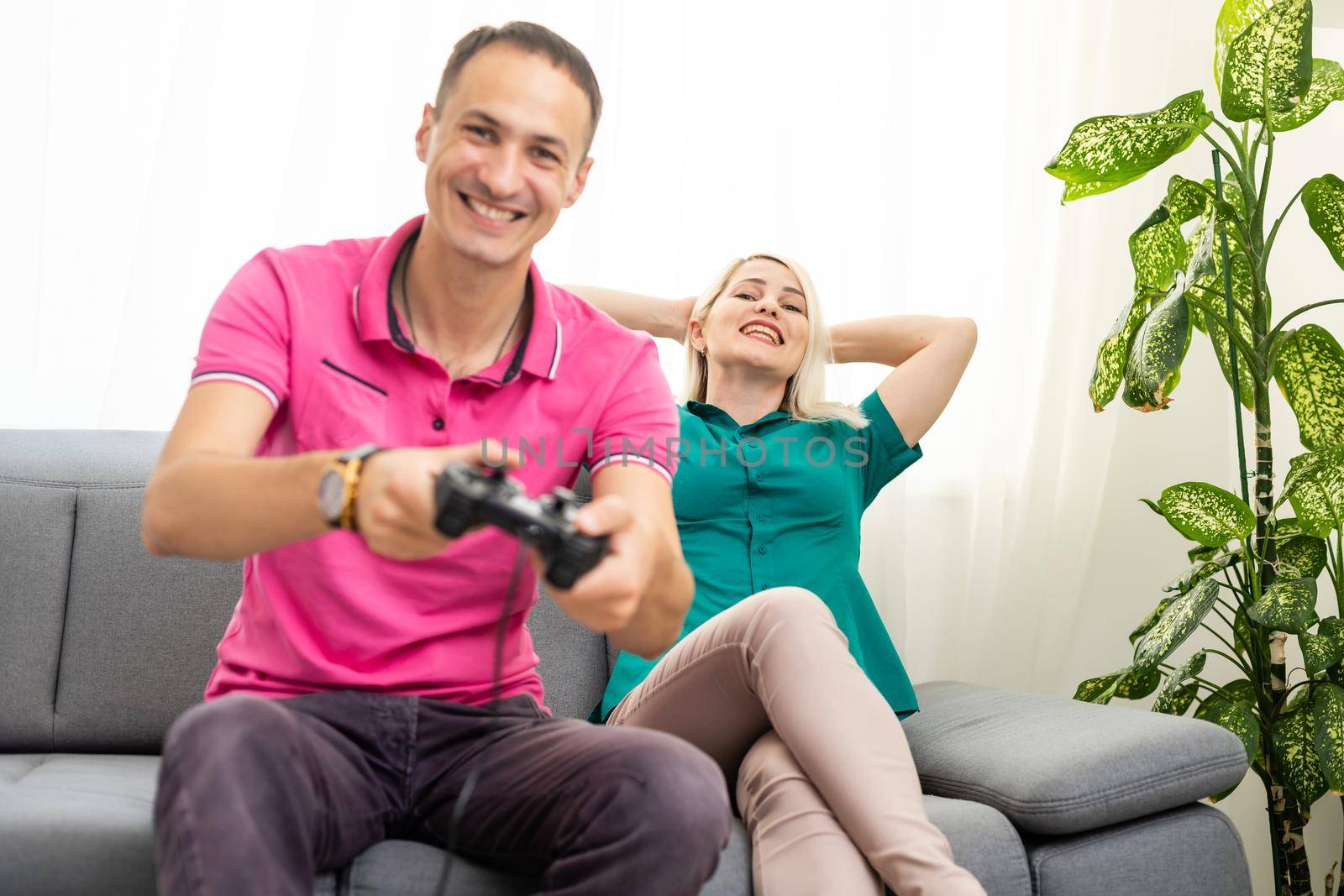 Couple playing video games at home by Andelov13