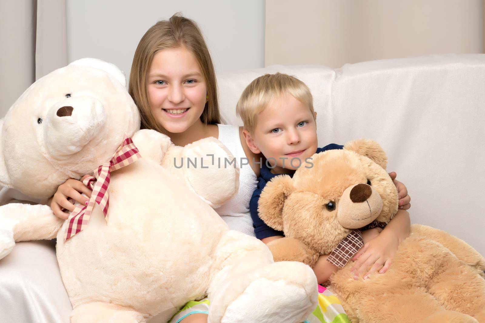 A teenage girl with her younger brother. studio photo session. The concept of family happiness.