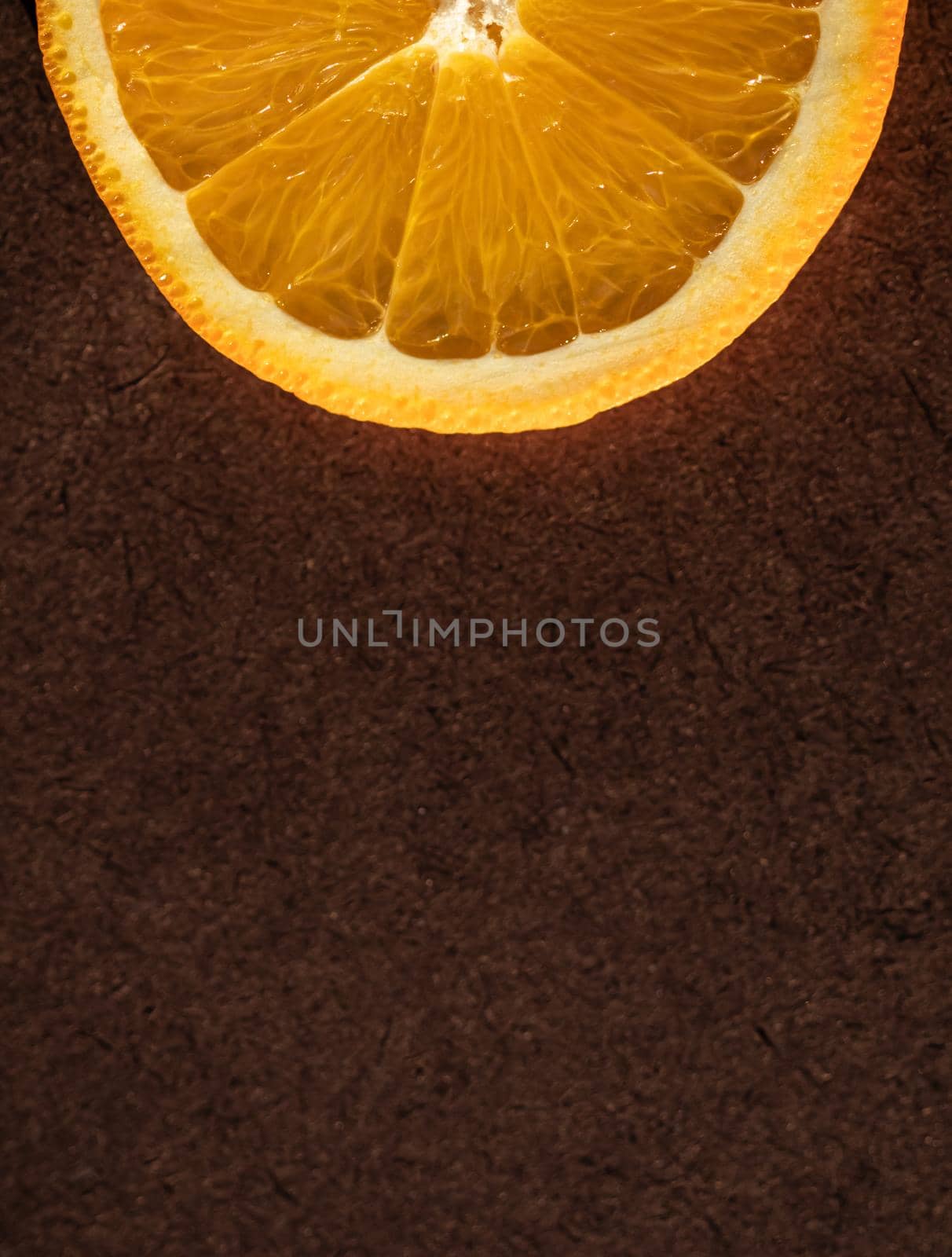 Part of an orange slice on a dark background. Place for your text