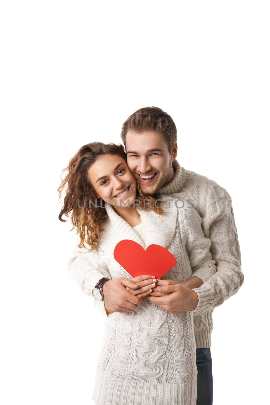 beautiful young couple holding a red heart isolated over white background