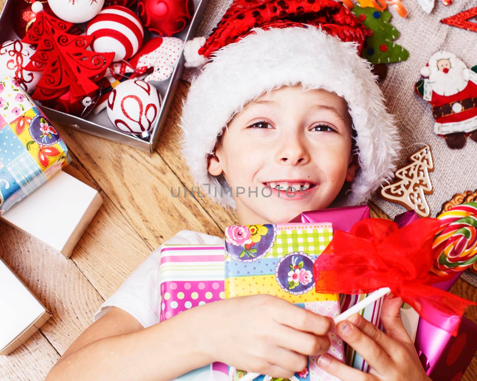 little cute boy with Christmas gifts at home. close up emotional happy smiling in mess with toys, lifestyle holiday real people concept close up
