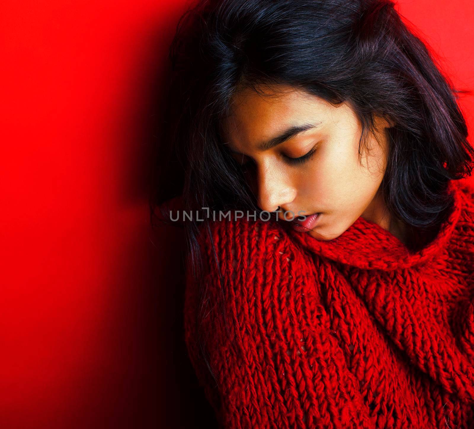 young pretty indian girl in red sweater posing emotional, fashion hipster teenage, lifestyle people concept closeup