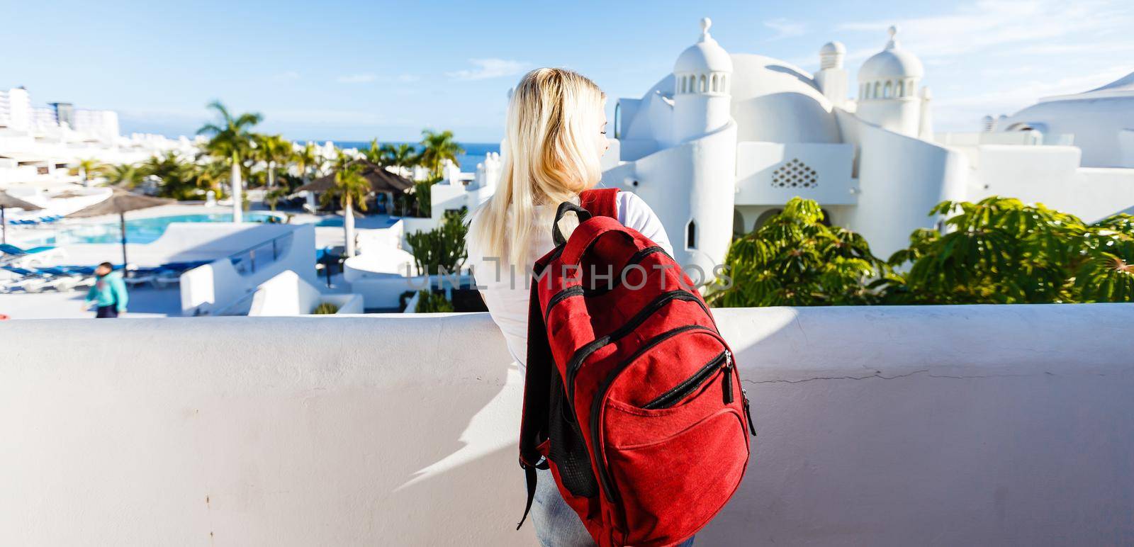 Traveller wearing a bag and white shirt exploring beautiful in Europe during summer sunset. tenerife