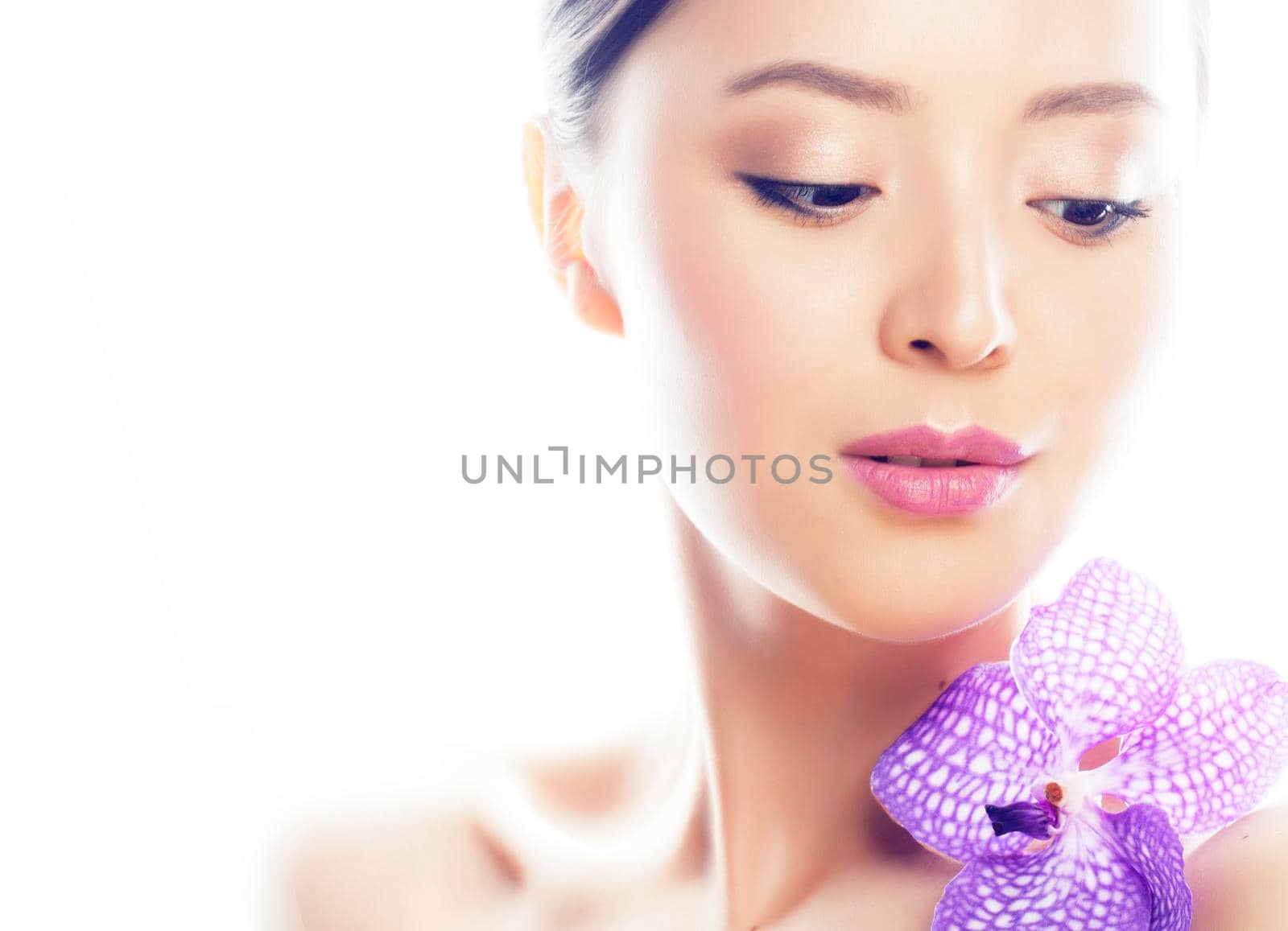 young pretty asian woman with flower purple orchid closeup isolated spa smiling casual