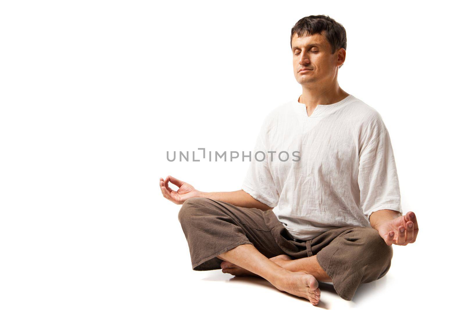 Peaceful man doing yoga and meditating - isolated over a white background