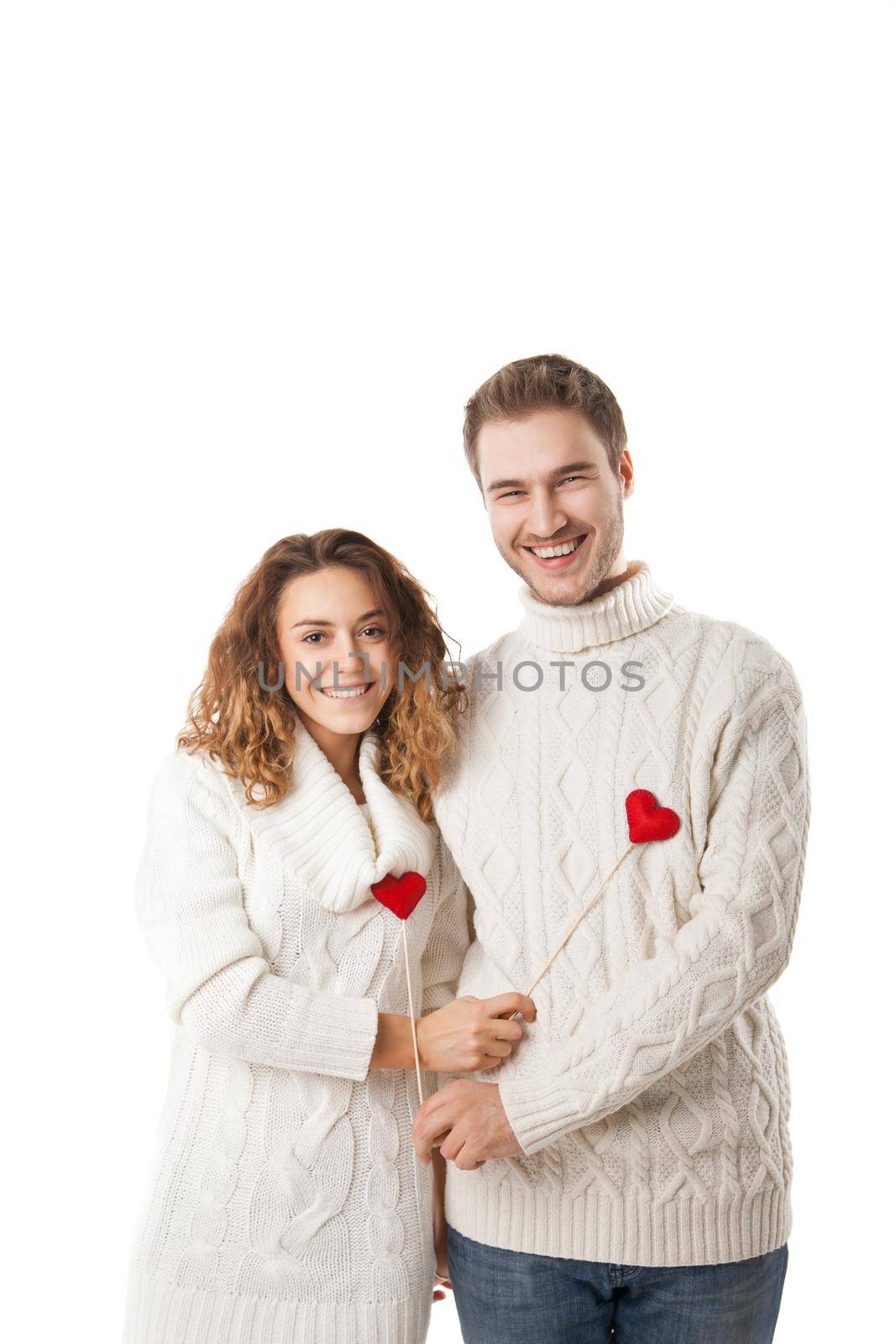 Portrait of joyful couple holding red hearts and laughing isolated on white