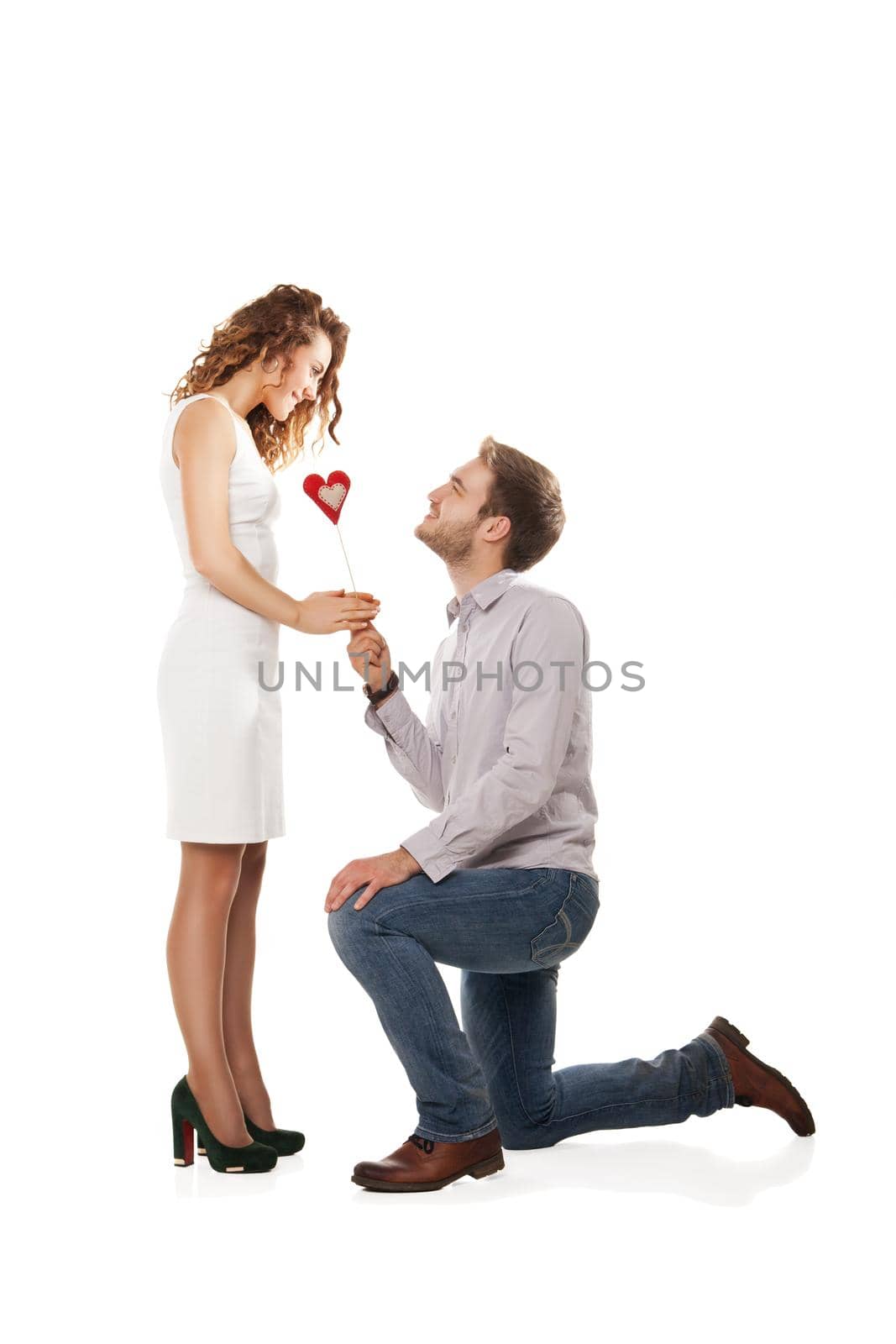 Portrait of joyful couple holding red heart isolated over white