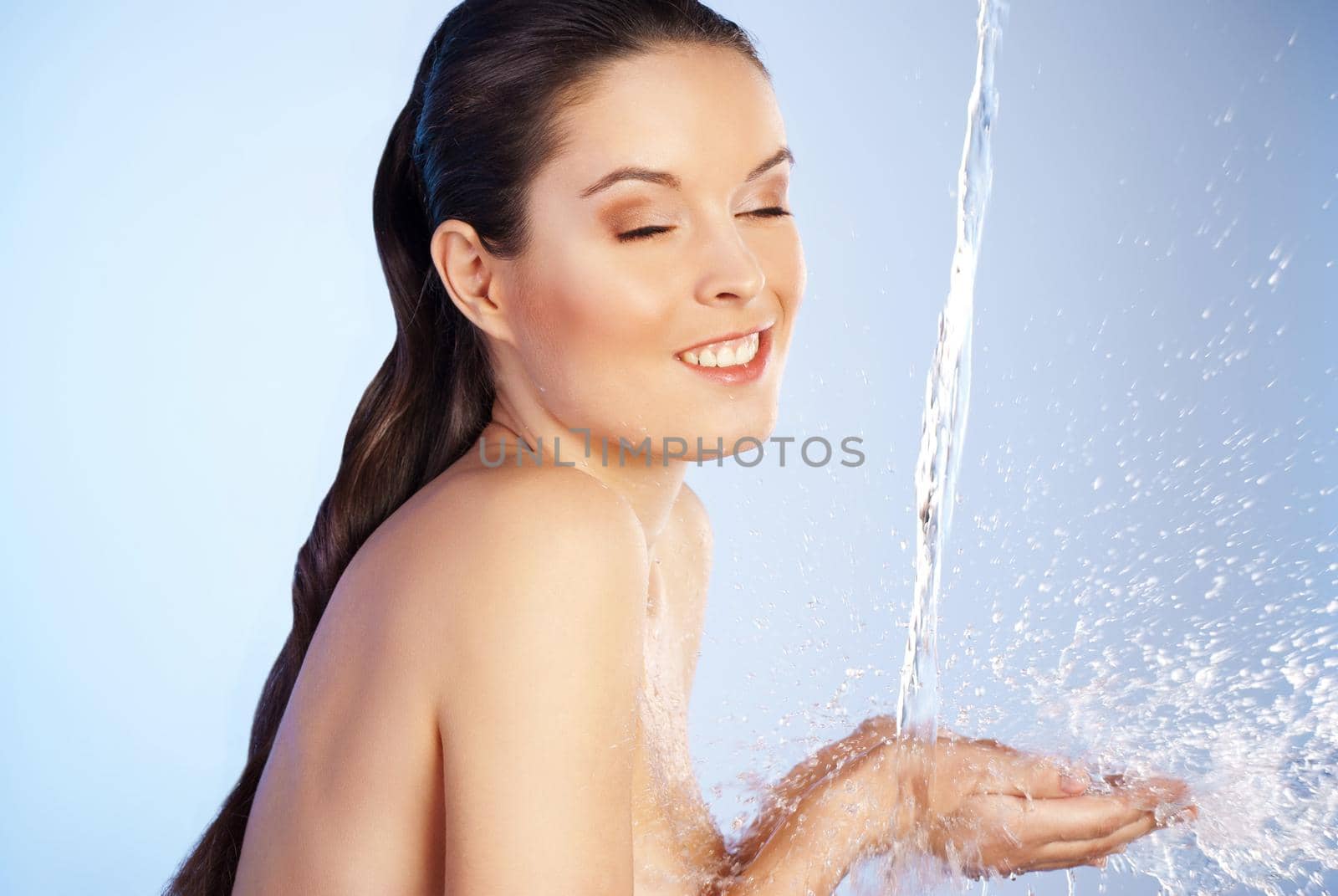 Portrait of young sensuality beautiful woman under the stream of water - blue background