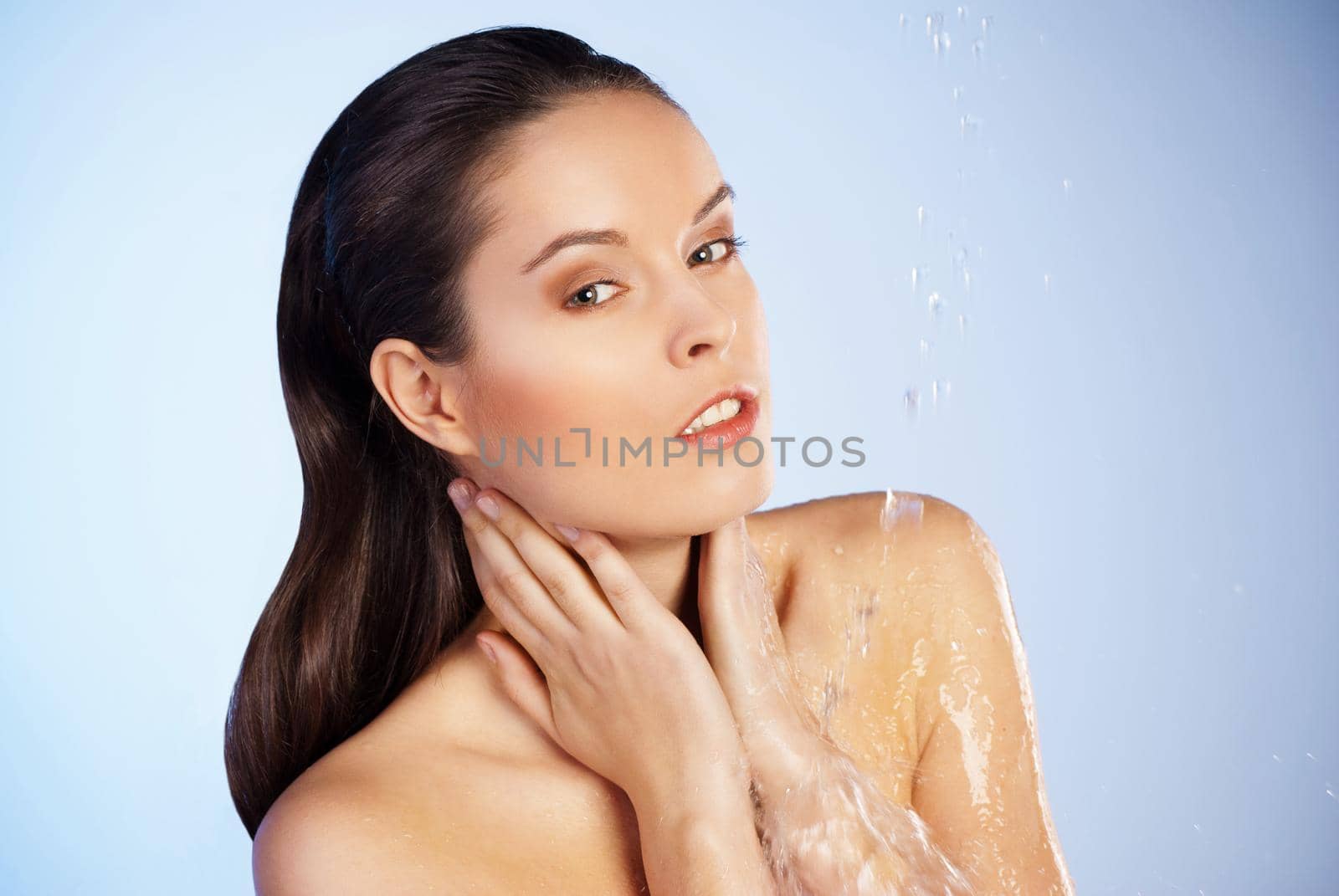 Portrait of young sensuality beautiful woman under the stream of water - blue background