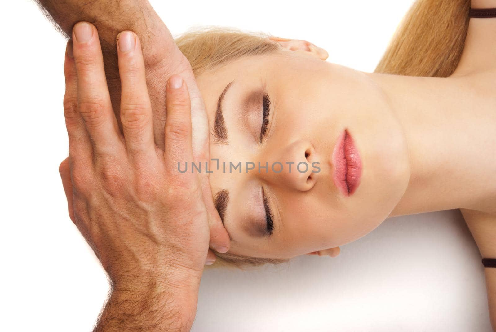 Young bright woman receiving a head massage in a spa centre