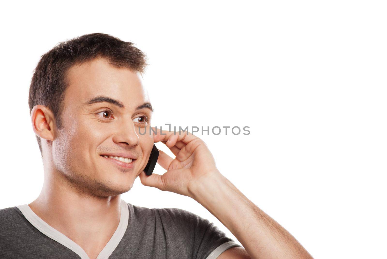 Young and healthy man answering the phone against a white background