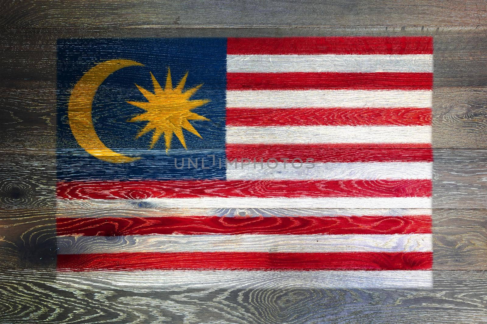 A Malaysia flag on rustic old wood surface background moon star red white stripes of glory Malay
