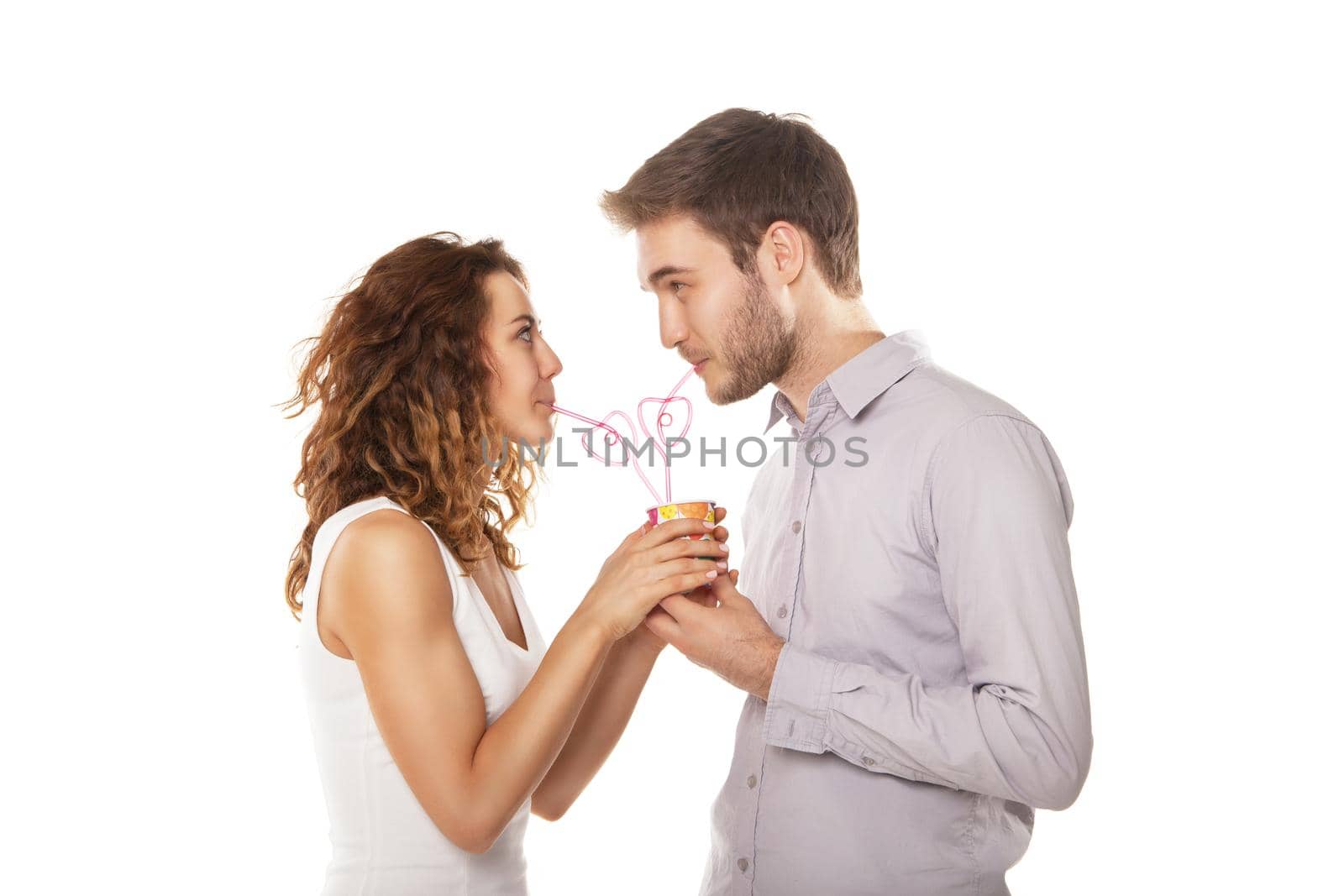 couple in love drink from the same glass isolated on white