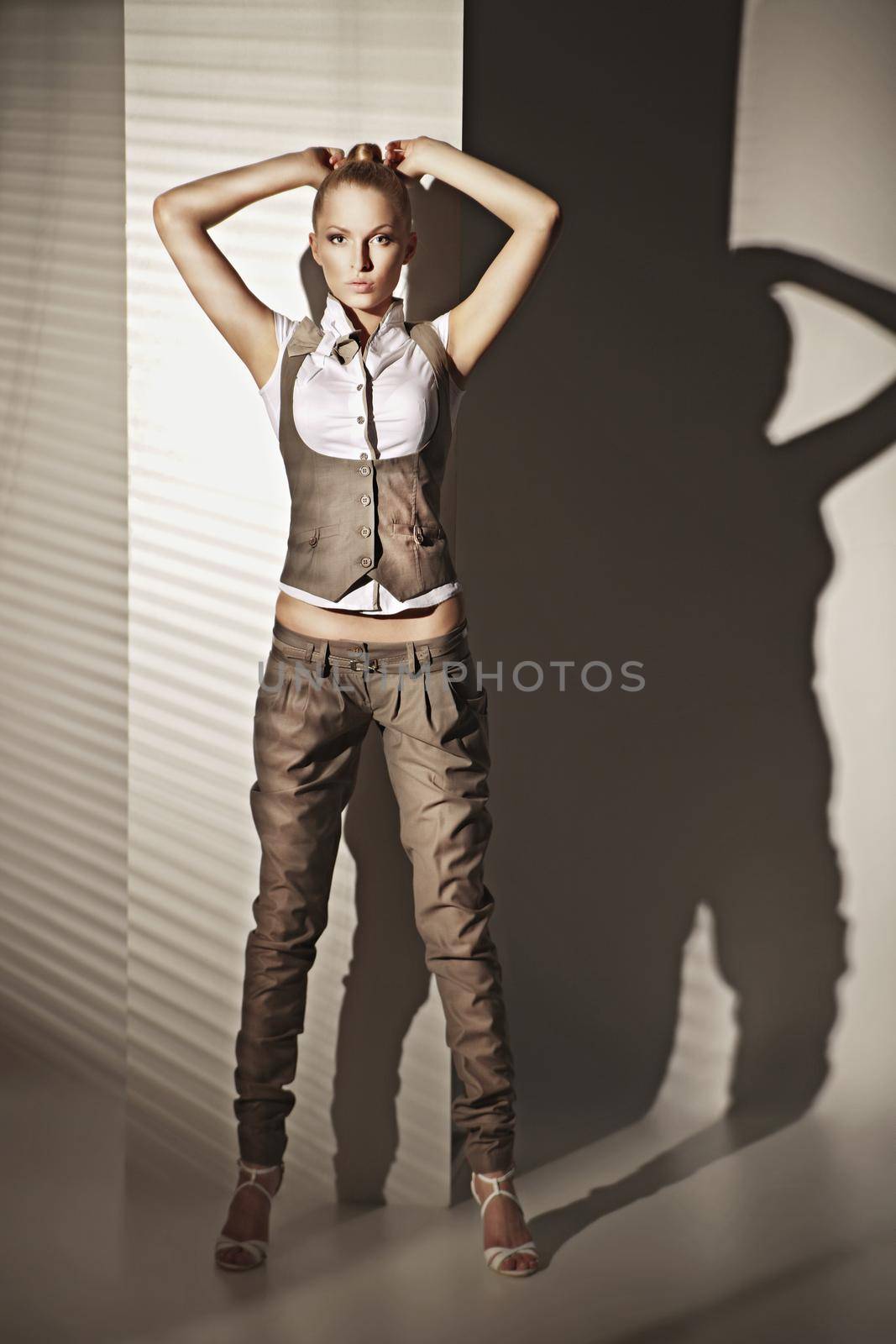 Fashion photo of sensual blonde woman in suit with shadow of jalousie