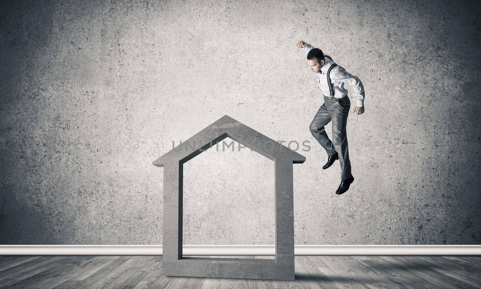 Determined businessman going to break with fist house concrete figure