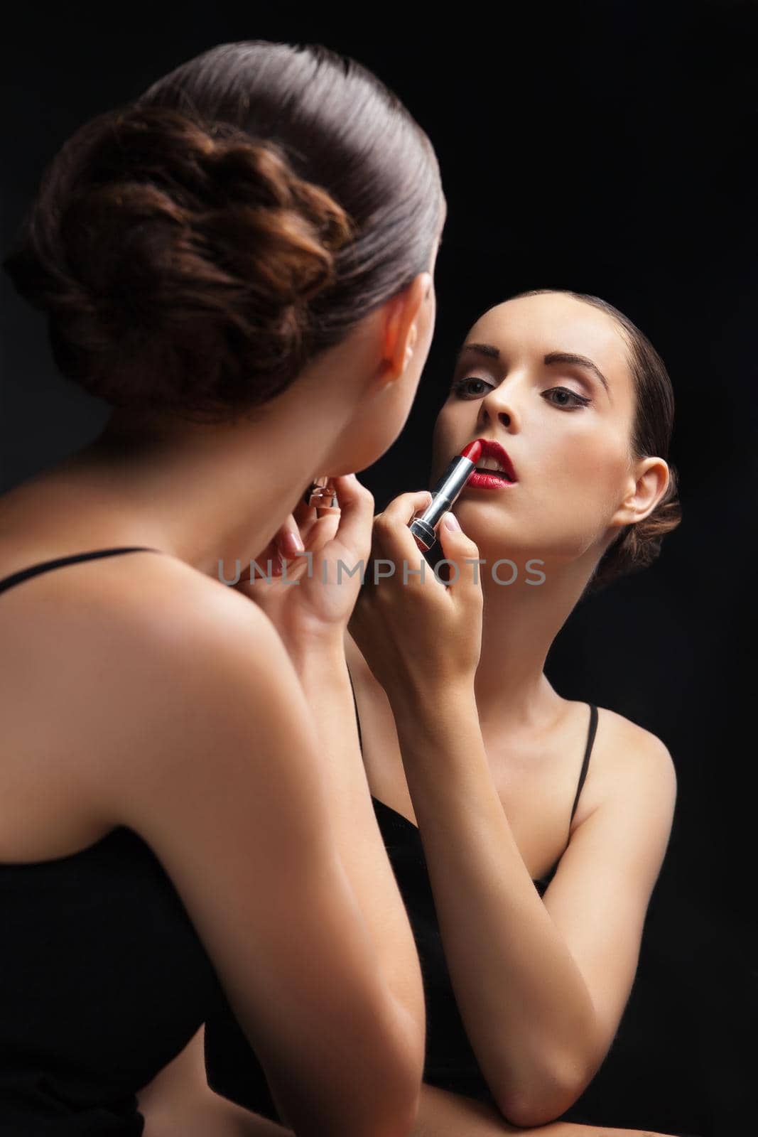 Beautiful young woman near mirror with lipstick by Julenochek