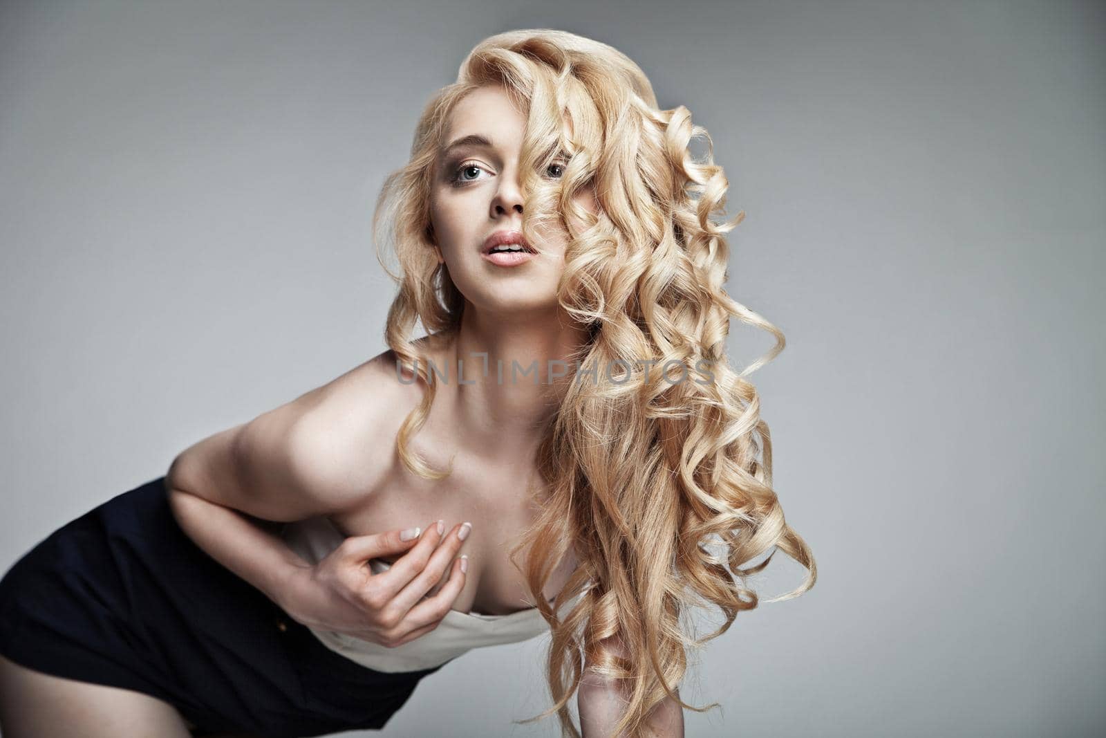 Well-being and spa. Sensual woman model with shiny curly long blond hair. Health, beauty, wellness, haircare, cosmetics and make-up