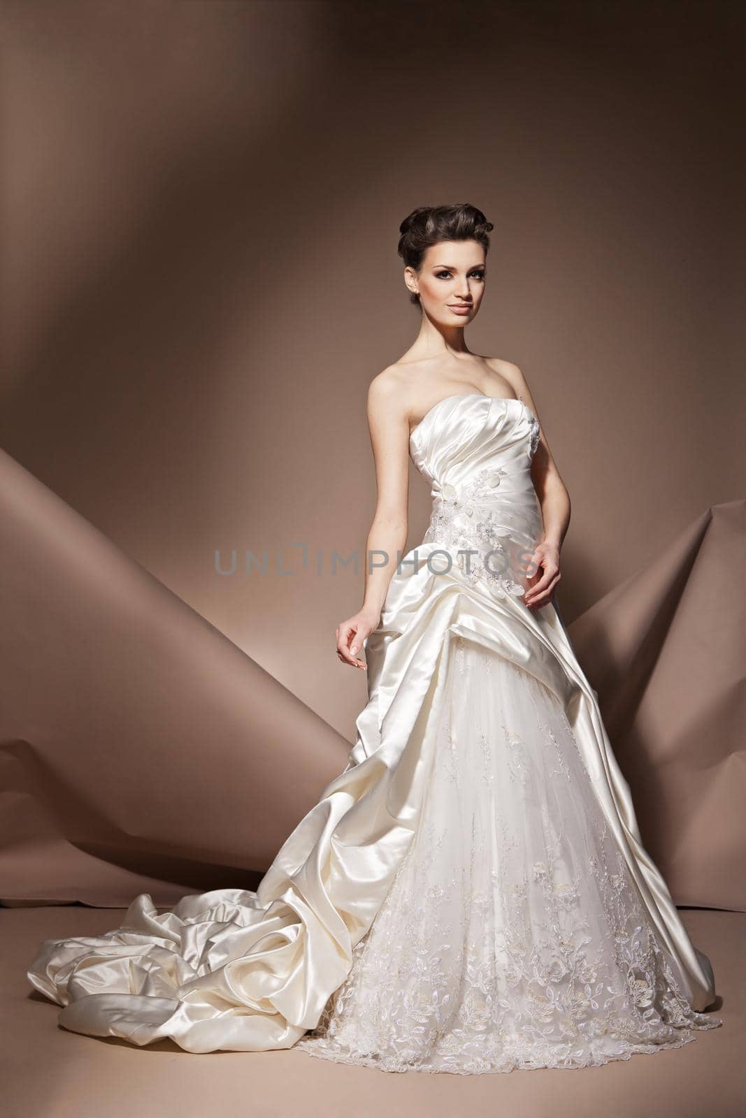 The beautiful young woman posing in a wedding dress