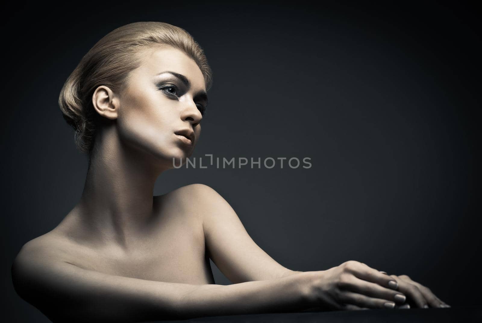 Beautiful high fashion female model with abstract hair style behind the table