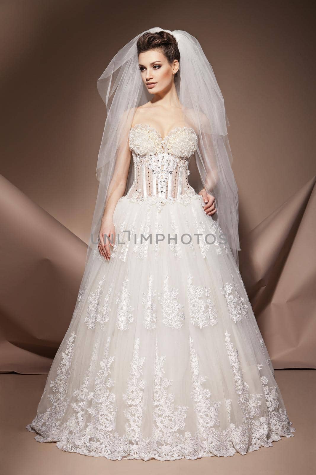 The beautiful young woman posing in a wedding dress