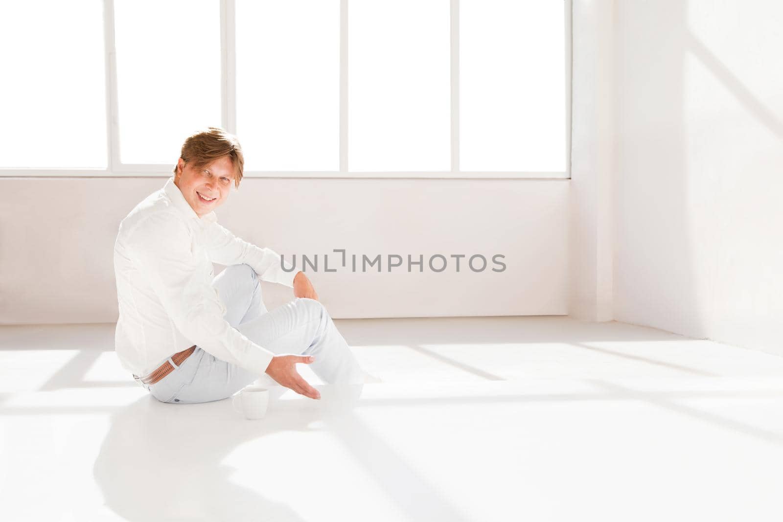 Attractive man and inviting someone to have a tea in room