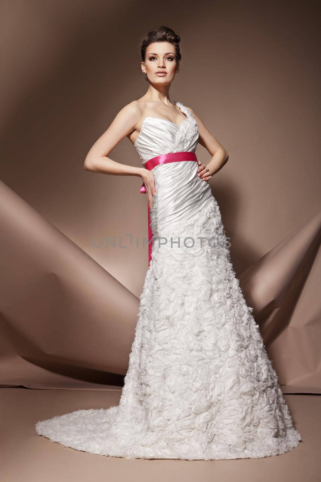 The beautiful young woman posing in a wedding dress