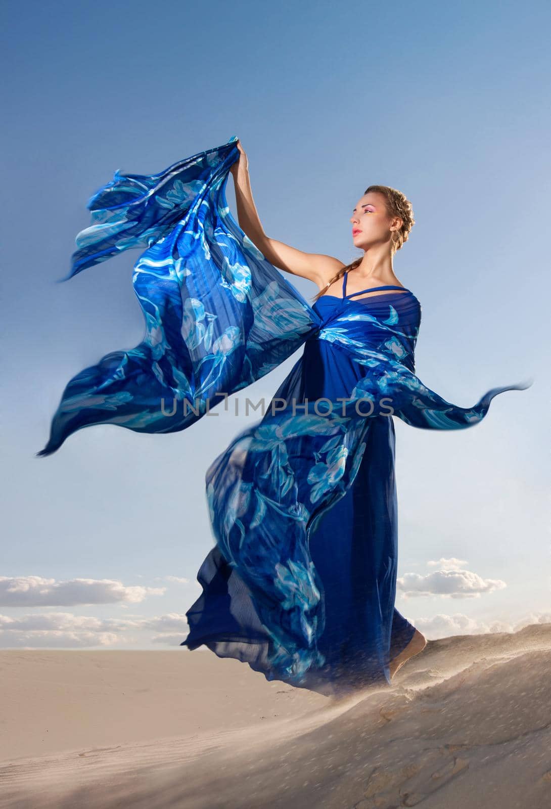 Portrait of a beauty woman in blue dress on the desert
