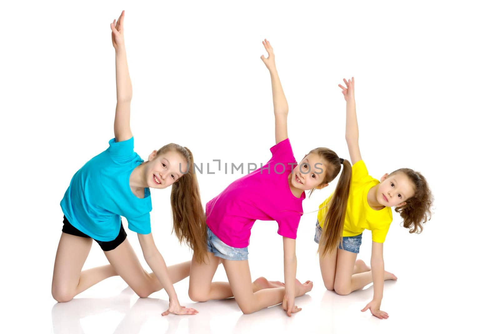 A group of cheerful little girls-gymnasts performing various gymnastic and fitness exercises. The concept of an active way of life, a happy childhood. Isolated on white background.