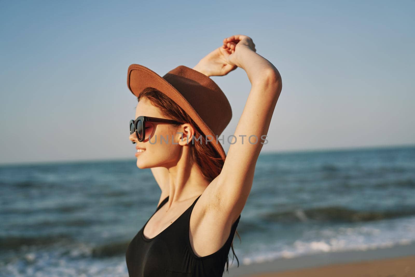 woman in a hat sunglasses by the ocean travel sun. High quality photo