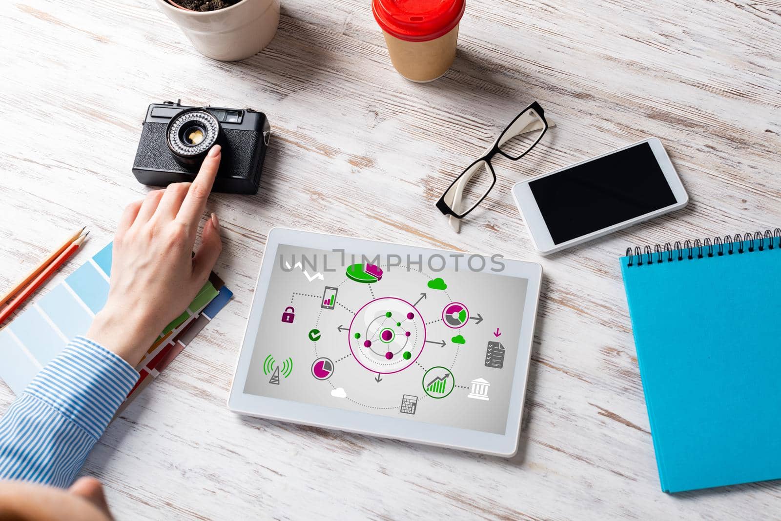 Blogger sitting at desk with tablet computer and camera. Mobile smart devices in business processes. Business occupation and innovation. Corporate office workplace with business woman at wooden desk.