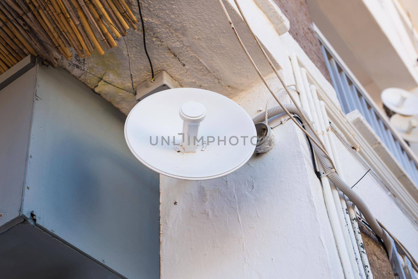 satellite dish and TV antennas on the house roof with blue sky background