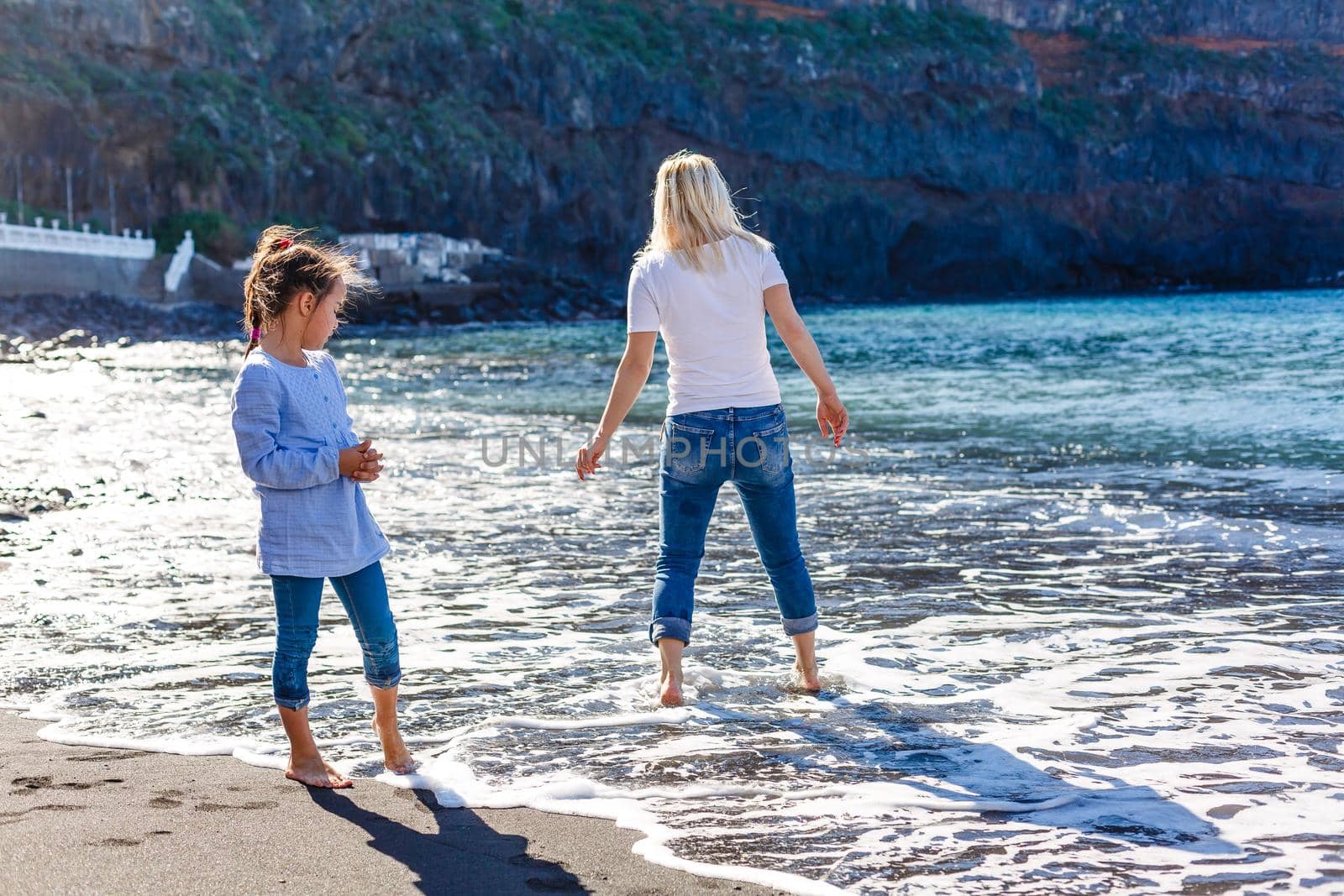 Family holiday on Tenerife, Spain. Mother with children outdoors on ocean. Portrait travel tourists - mom with kids. Positive human emotions, active lifestyles. Happy young family on sea beach