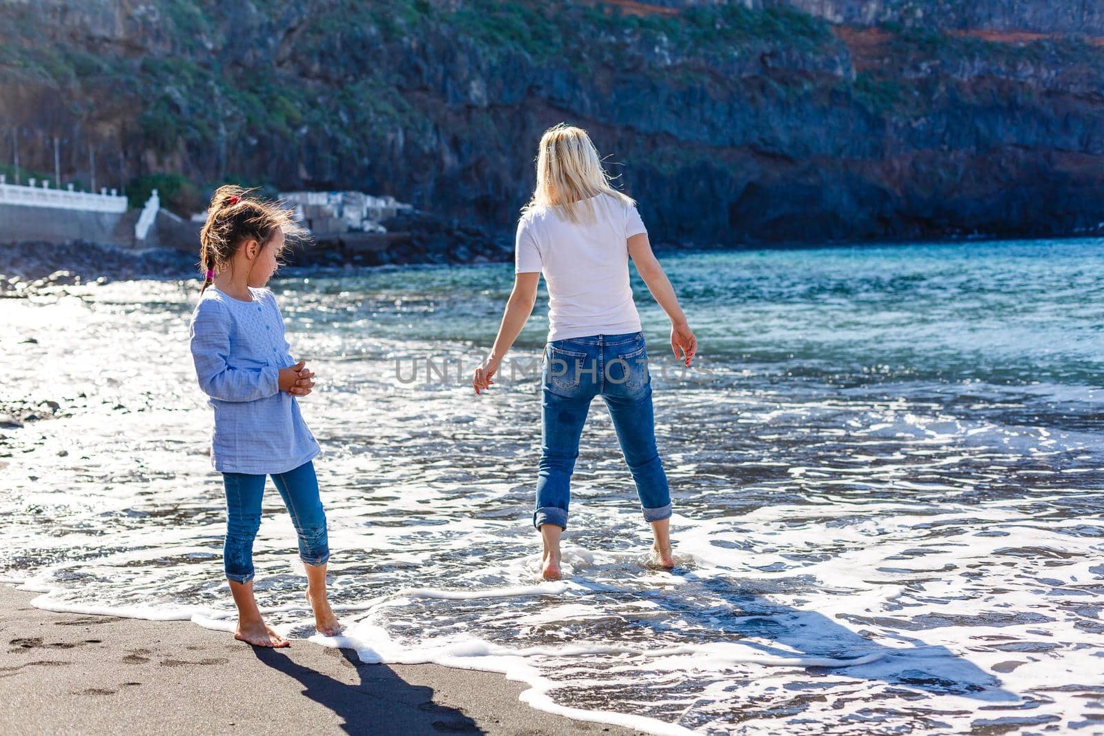 Family holiday on Tenerife, Spain. Mother with children outdoors on ocean. Portrait travel tourists - mom with kids. Positive human emotions, active lifestyles. Happy young family on sea beach by Andelov13