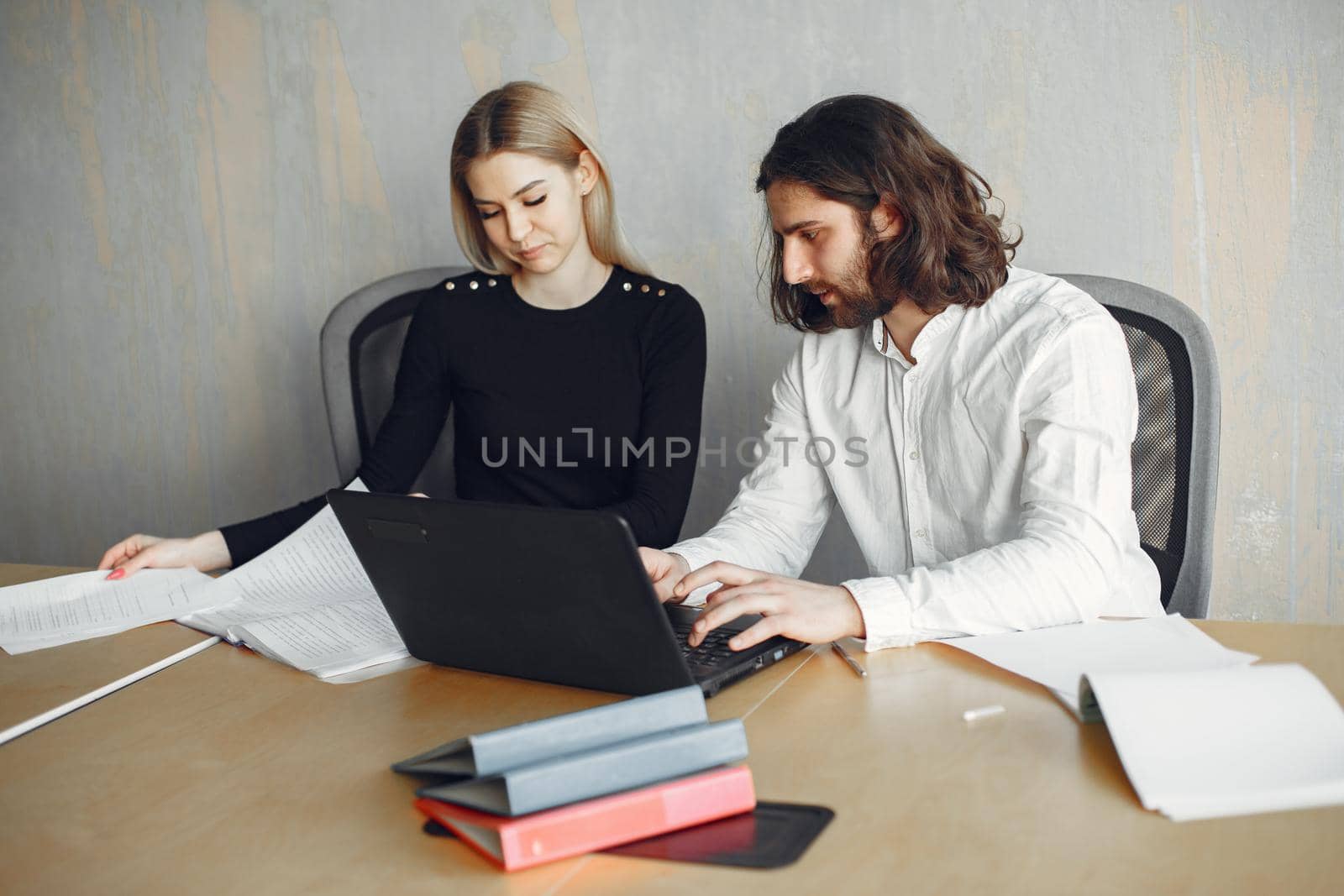 Handsome man in a white shirt. Partners together. Guy with a laptop.