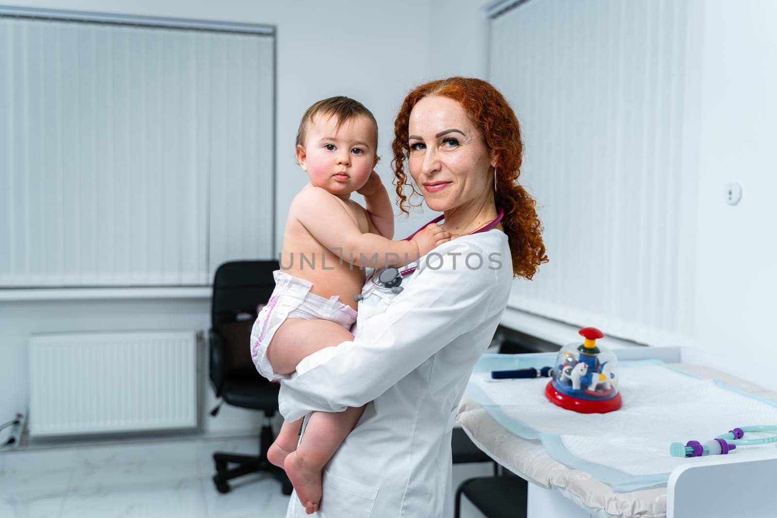 Little girl at doctor for checkup. Doctor pediatrician and baby patient. Child patient at doctor appointment. Pediatrician checking kid's health. Medical examination by a neonotologist doctor of baby by Tomashevska