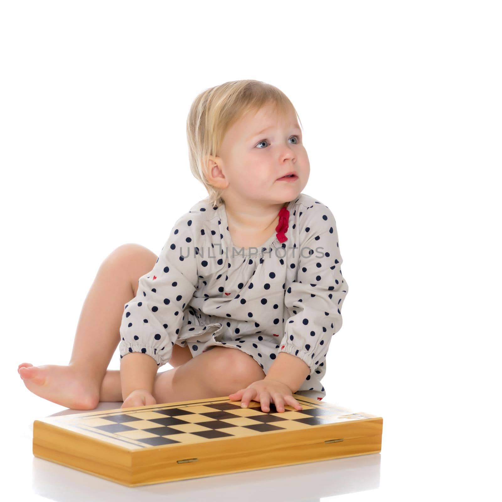 A little girl is playing chess. The concept of creative education of a child, training of thinking. Isolated on white background