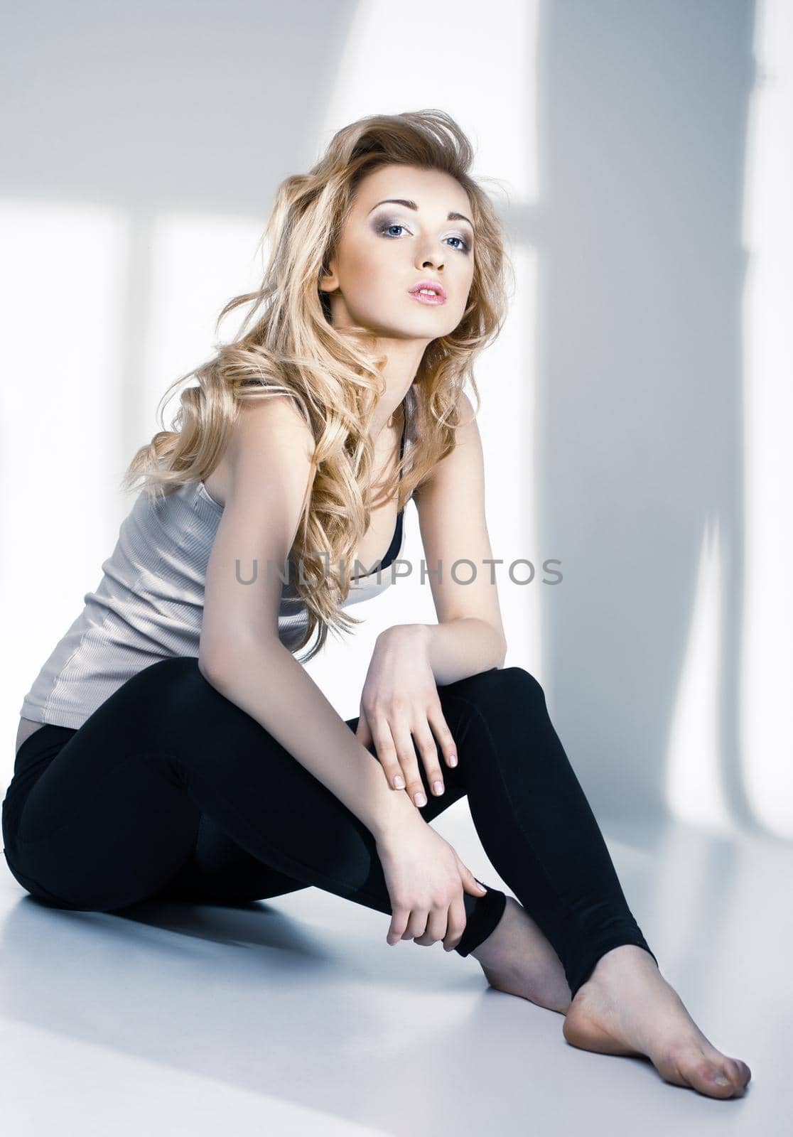 Portrait of beautiful young girl in the light of the window on white background
