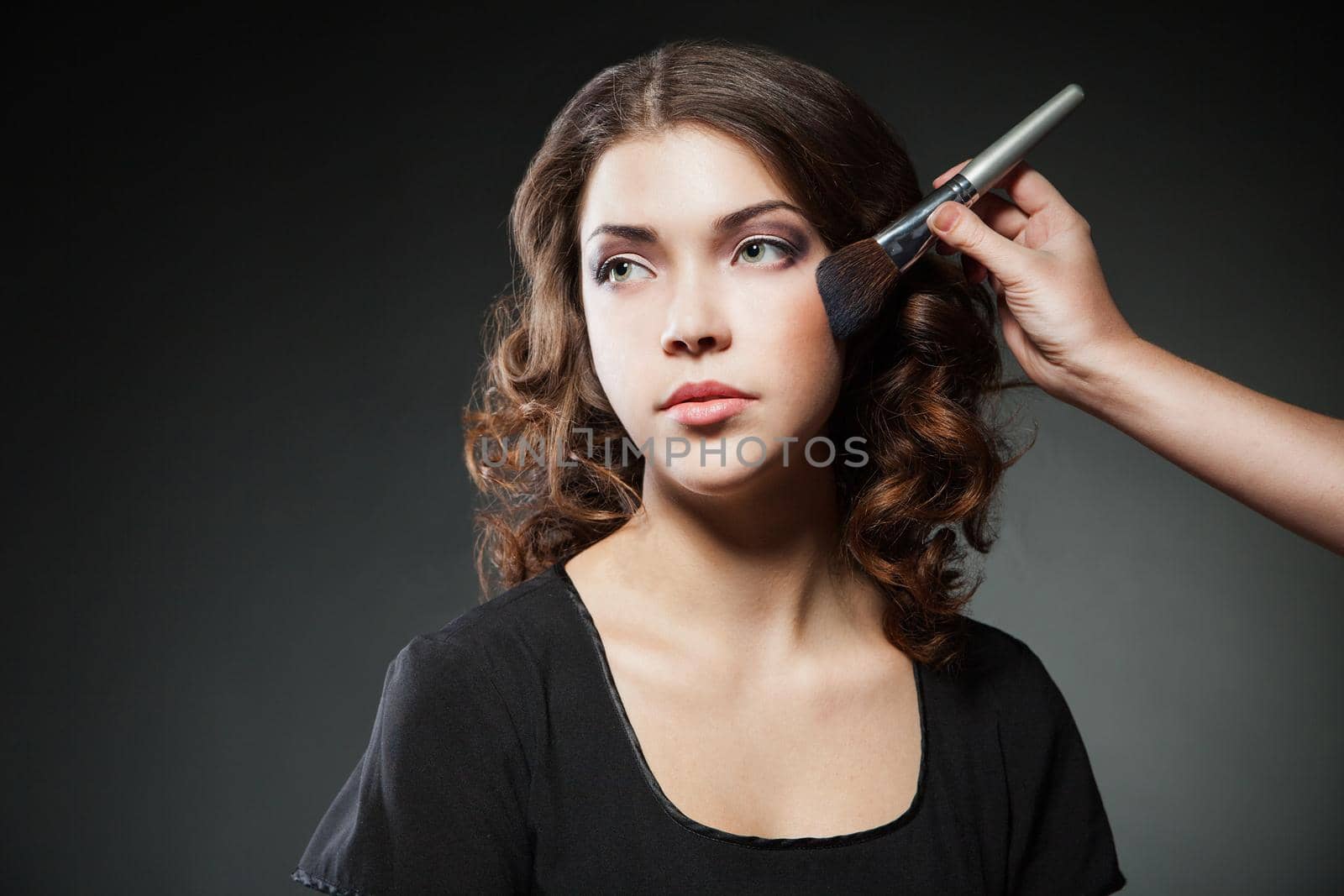 Makeup. Make-up Applying closeup. Cosmetic Powder Brush for Make up. Perfect Skin. On dark Background. Makeover