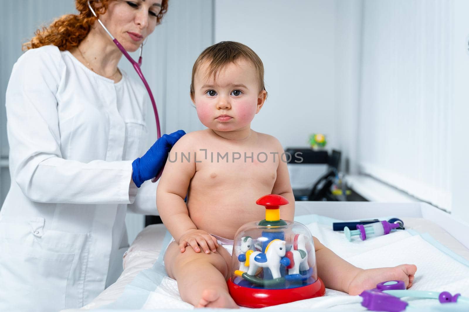 Little girl at doctor for checkup. Doctor pediatrician and baby patient. Child patient at doctor appointment. Pediatrician checking kid's health. Medical examination by a neonotologist doctor of baby by Tomashevska