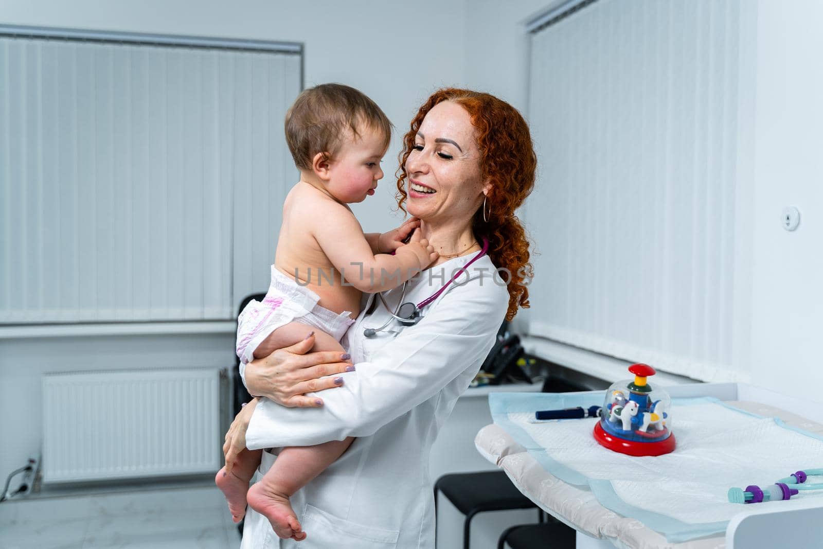 Pediatrician providing healthcare for her baby patient in the office of a specialized clinic for children. Neonatologist. Medical appointment little child one year old in the clinic. Health care of infant, children, kid.