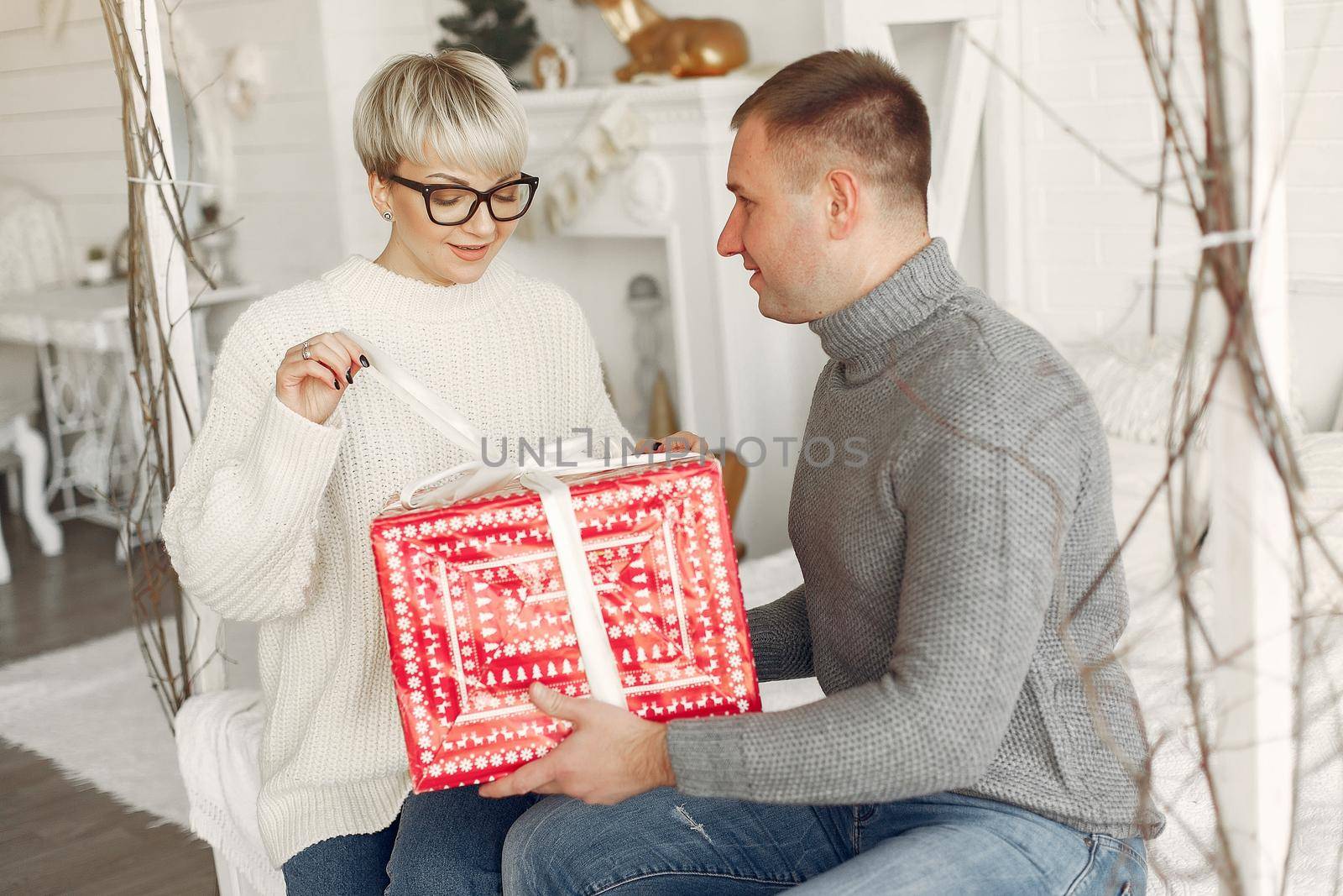 Family at home. Couple near christmas decorations. Woman in a gray sweater.