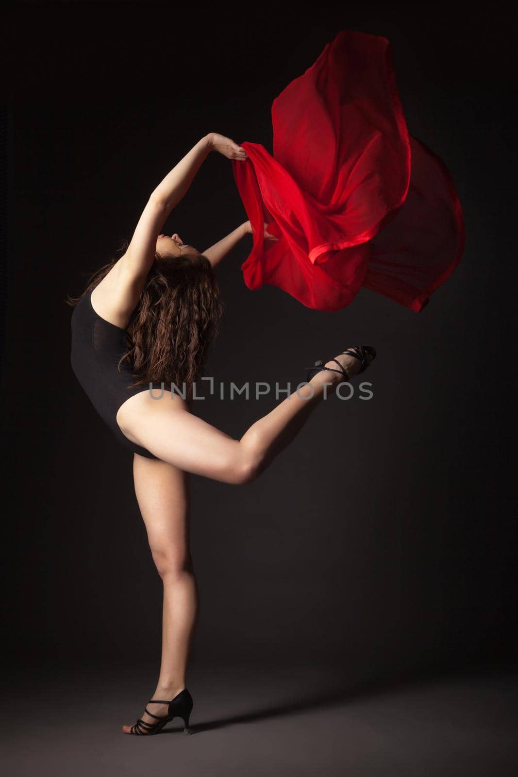 Modern dancer with red fabric posing on grey by Julenochek