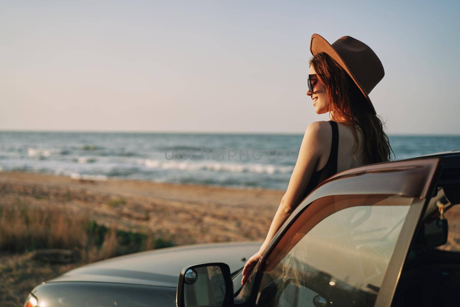 pretty woman in sunglasses near the car on the beach travel lifestyle. High quality photo