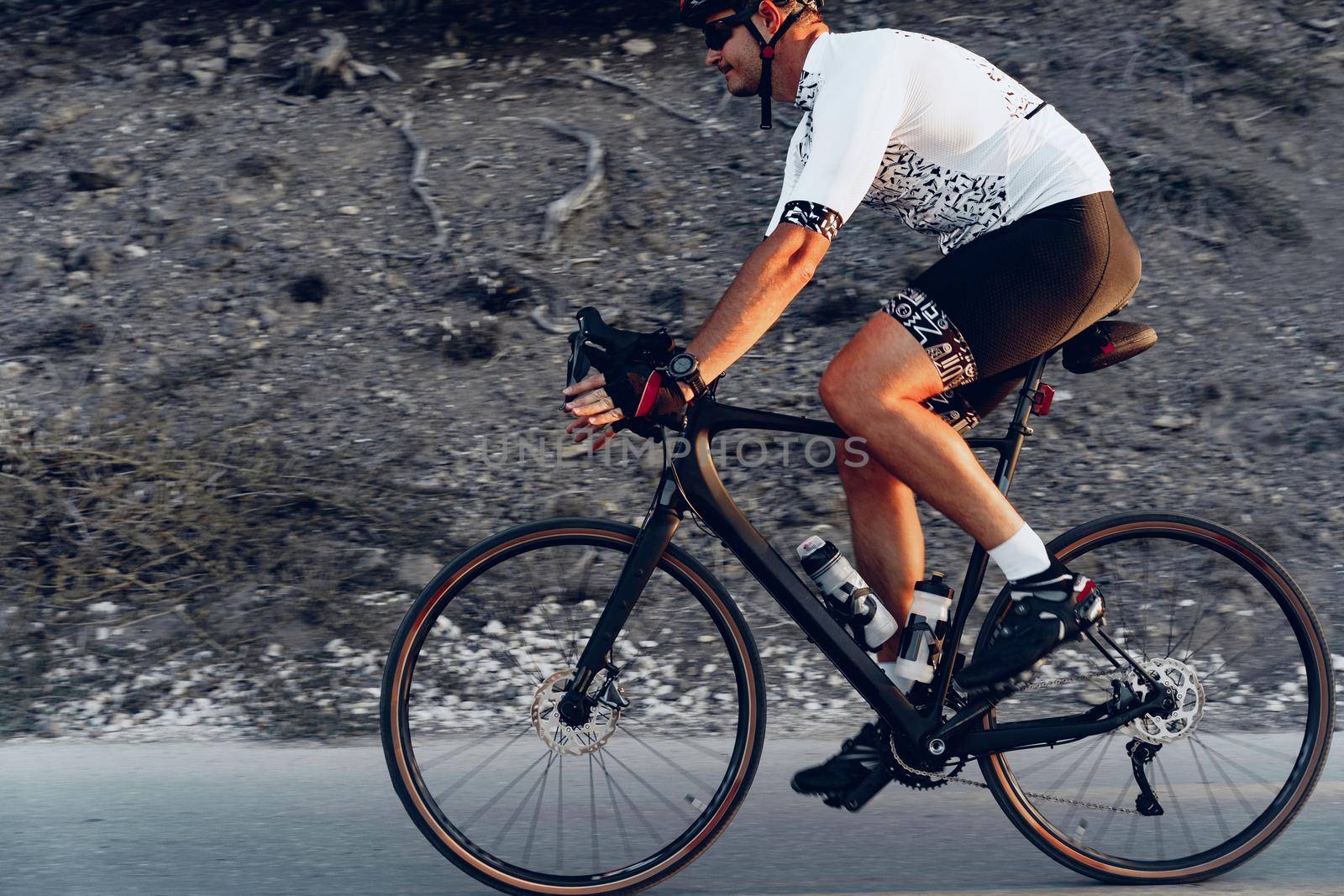 Professional man cyclist on a mountain road at sunrise