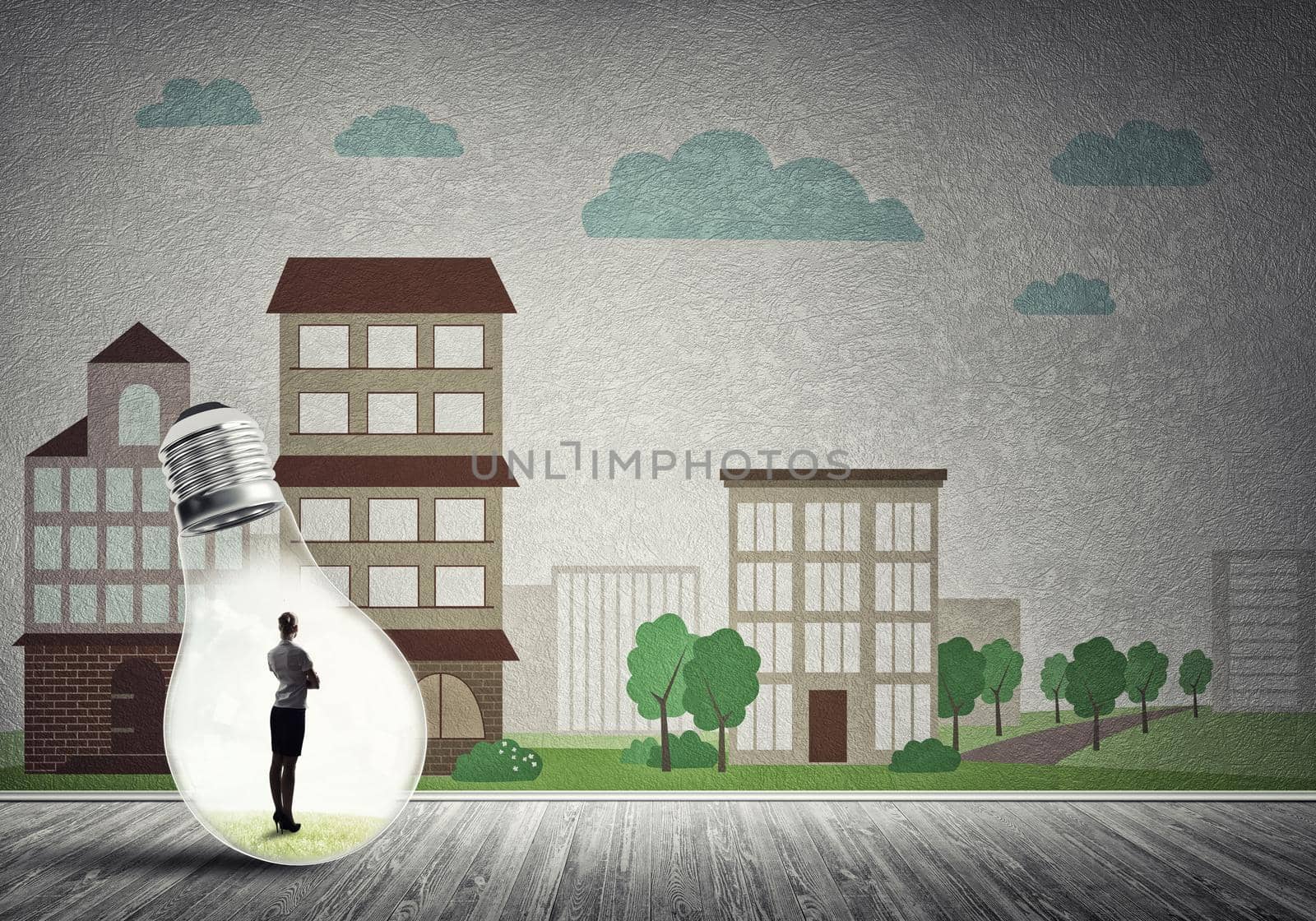 Businesswoman inside light bulb against city drawn concept