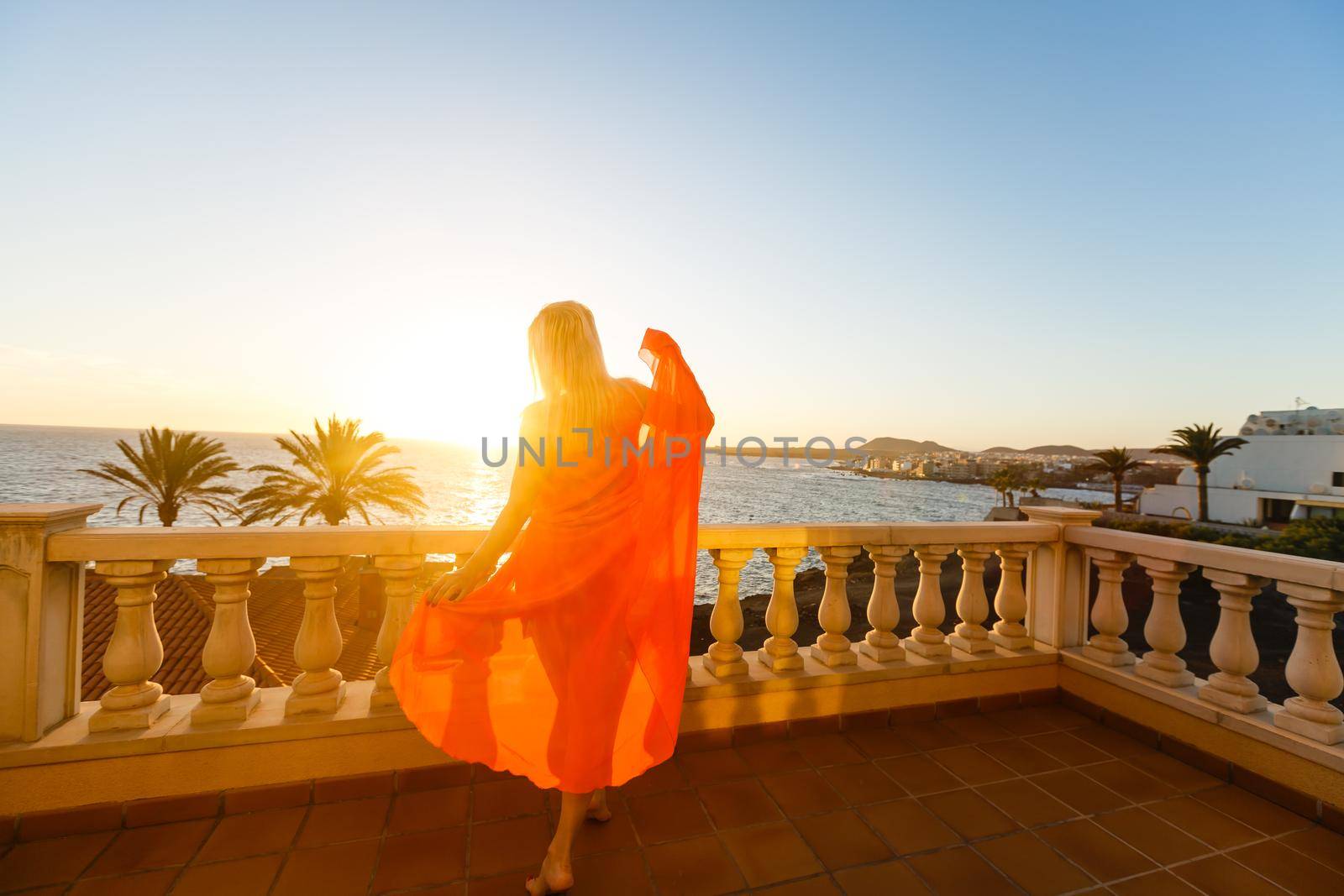 Woman looking on sea from balcony. Rear view