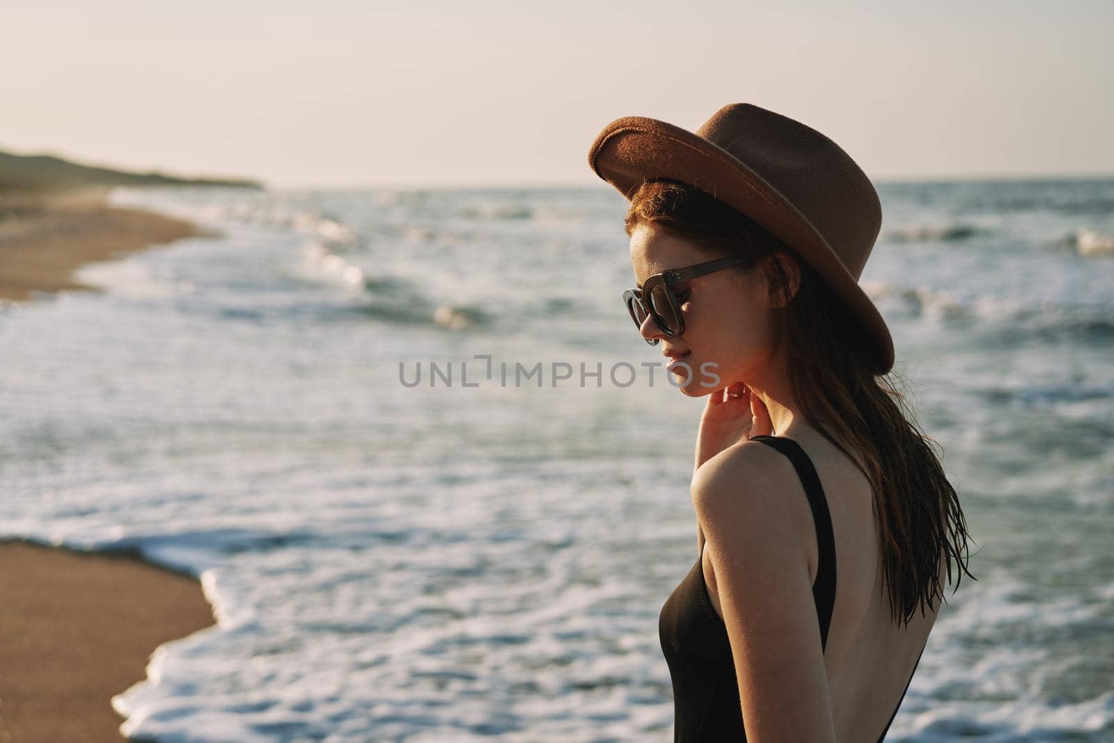 woman walking on the beach hat travel vacation sun. High quality photo
