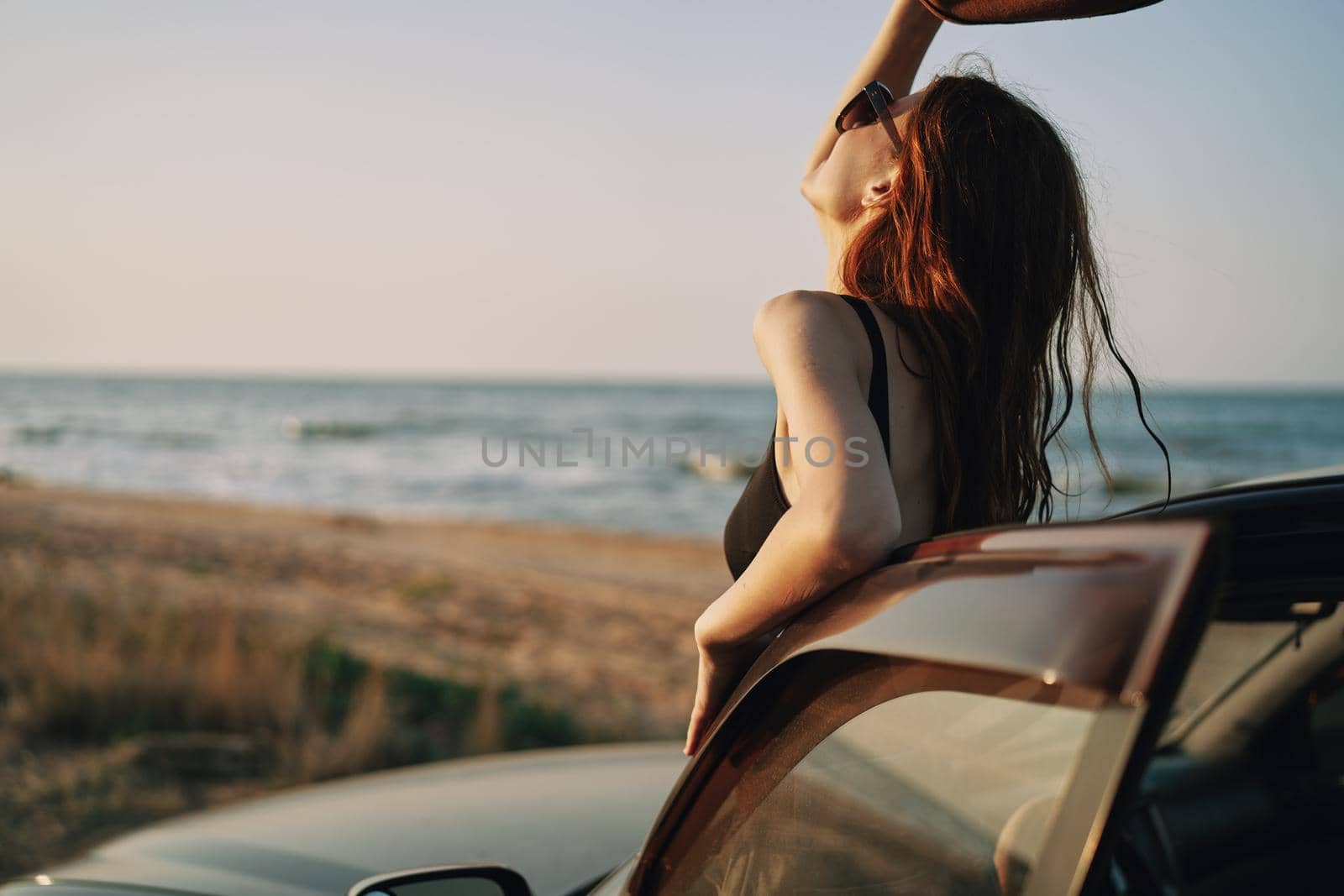 pretty woman in sunglasses near the car on the beach travel lifestyle. High quality photo