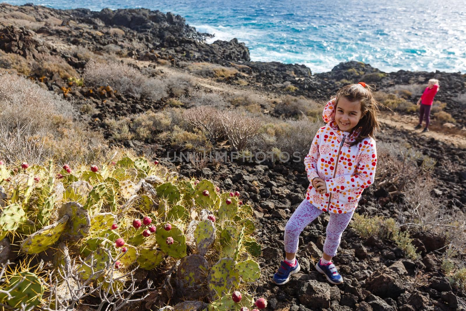 little girl stands near a cactus on the island of tenerife